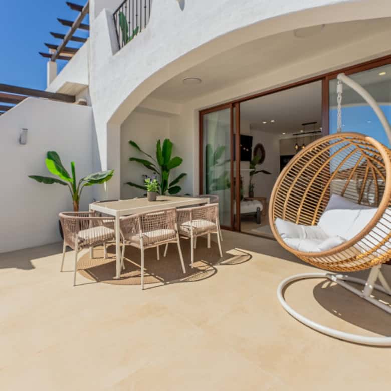 Refurbished townhouse terrace with outdoor dining and relaxing swing chair in Los Arqueros, Benahavi.