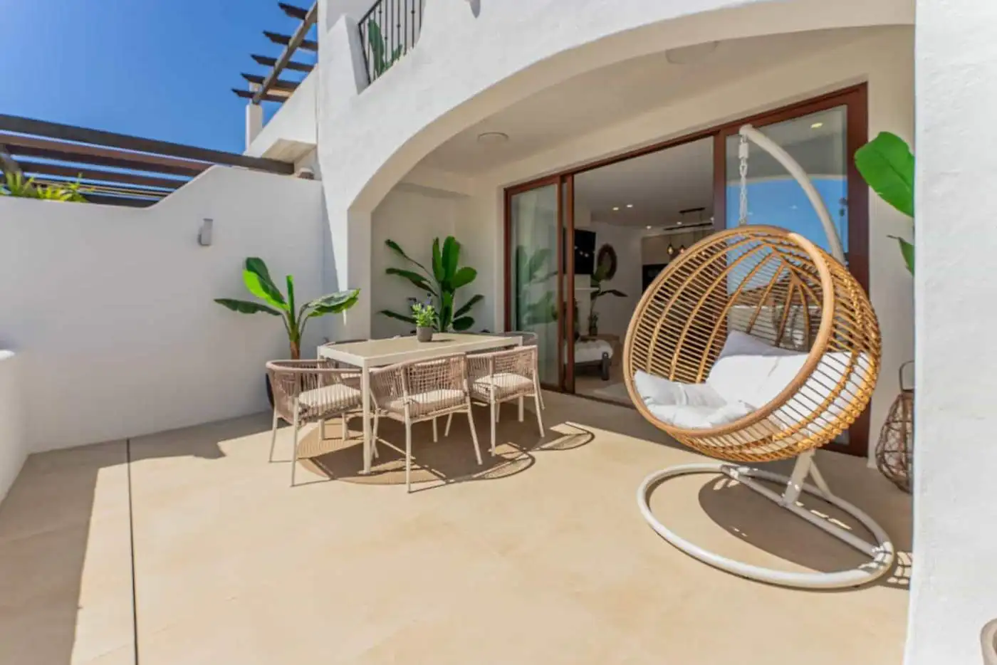 Refurbished townhouse terrace with outdoor dining and relaxing swing chair in Los Arqueros, Benahavi.