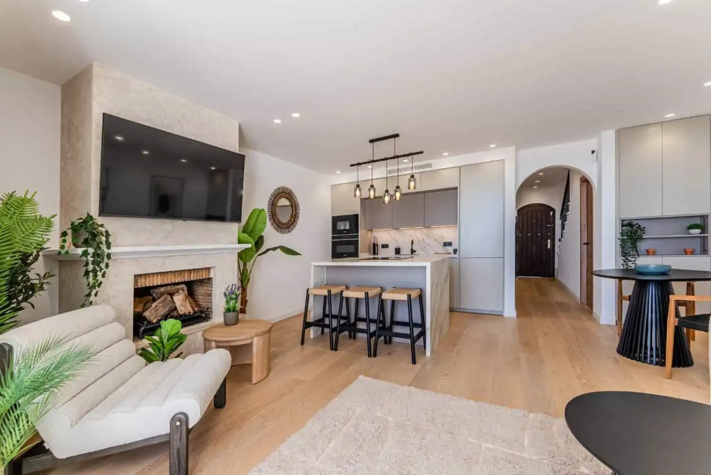 Spacious living room with contemporary decor, flat-screen TV, and natural light in Los Arqueros Bena.