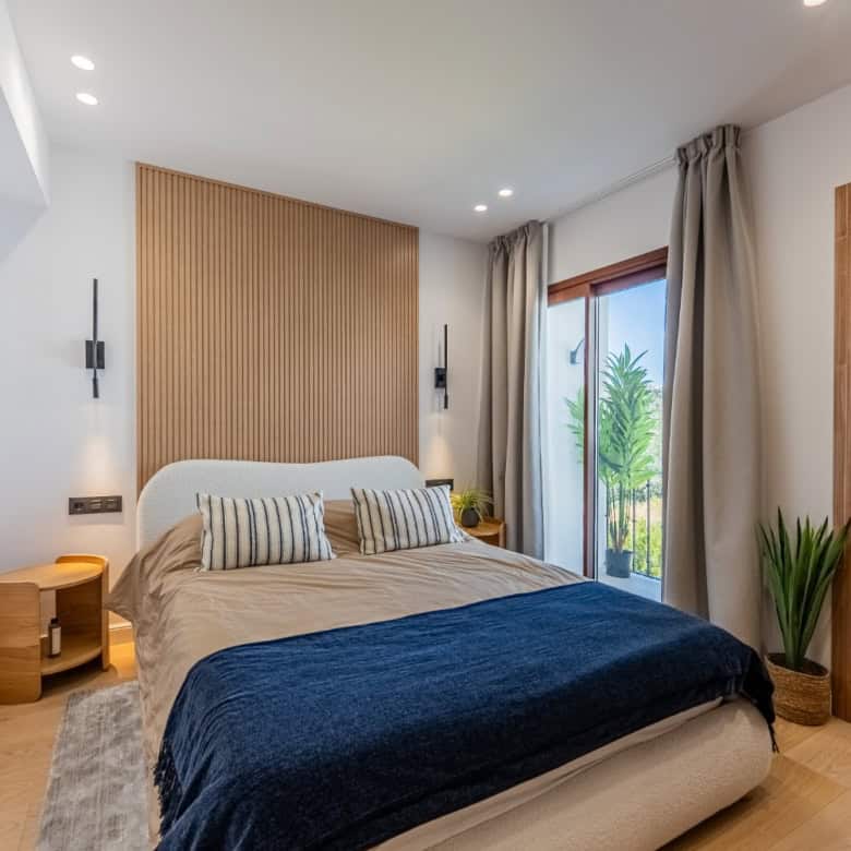 Beautifully furnished bedroom with balcony overlooking lush greenery in Los Arqueros Benahavis.