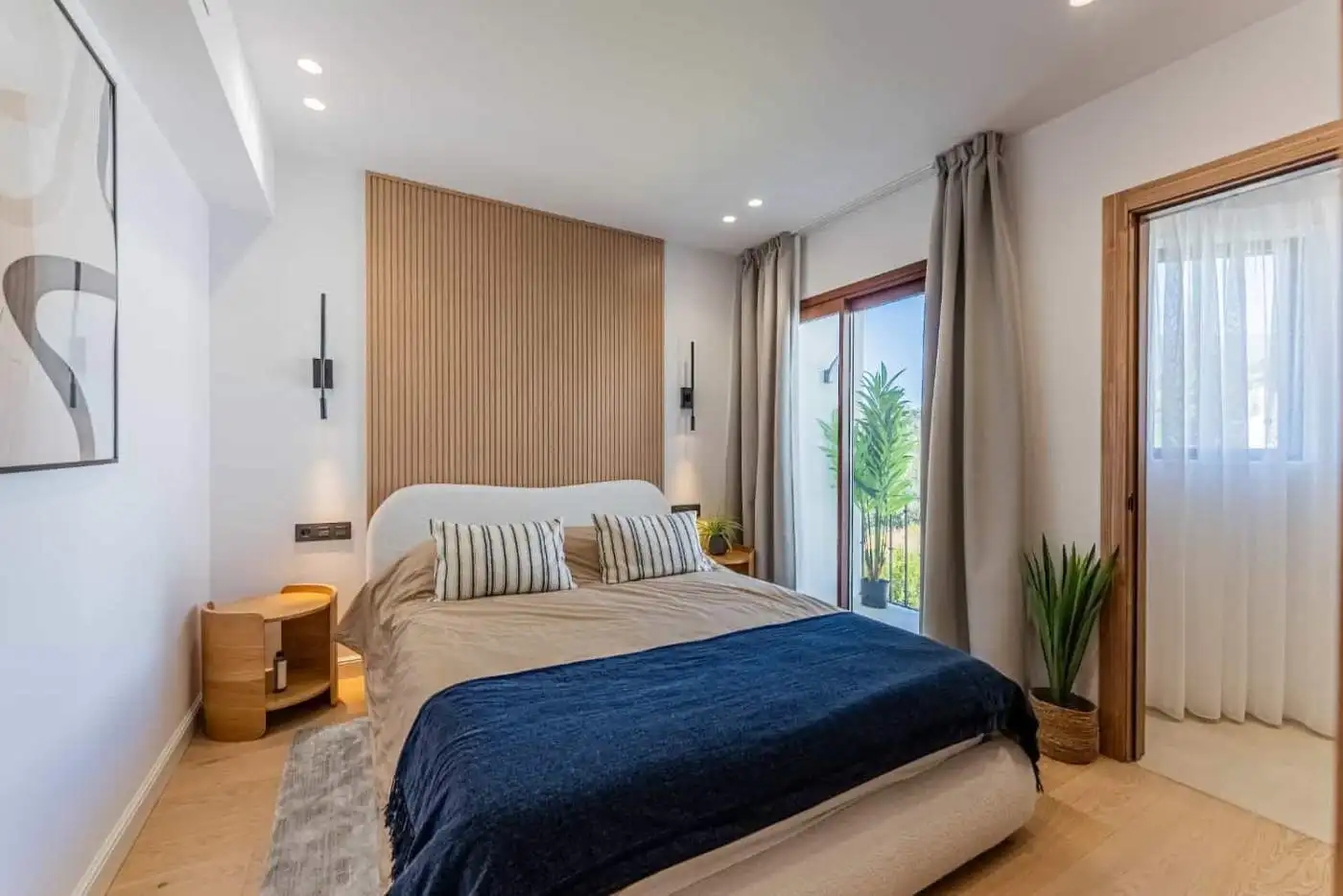 Beautifully furnished bedroom with balcony overlooking lush greenery in Los Arqueros Benahavis.