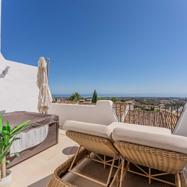 Modern terrace with sea views in Los Arqueros Benahavis, featuring comfortable outdoor furniture and.