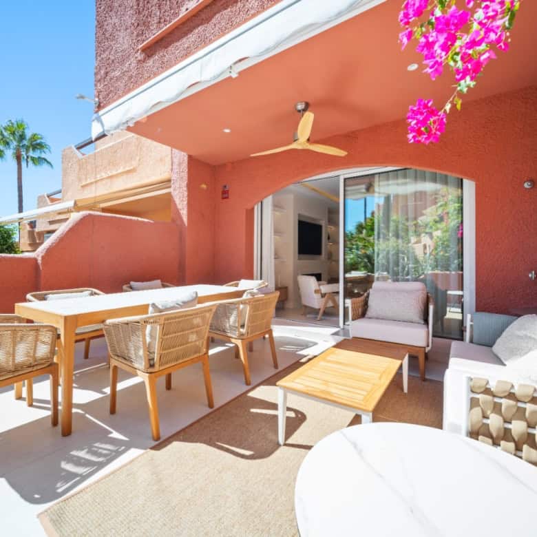 Elegant outdoor terrace with stylish furniture and vibrant flowers in El Palmeral, Nueva Andalucía.
