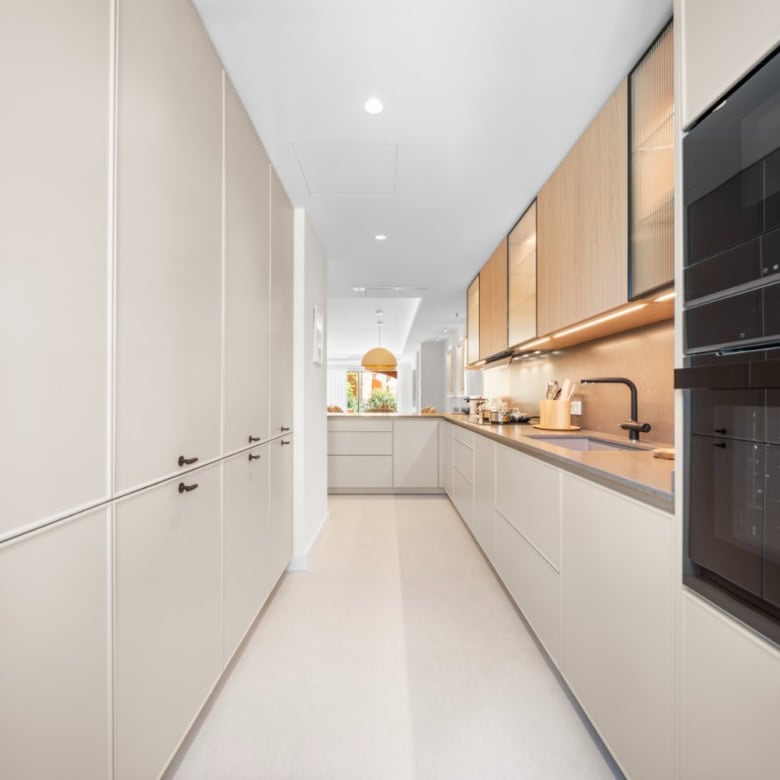 Modern kitchen with sleek cabinetry and built-in appliances in a luxury townhouse.
