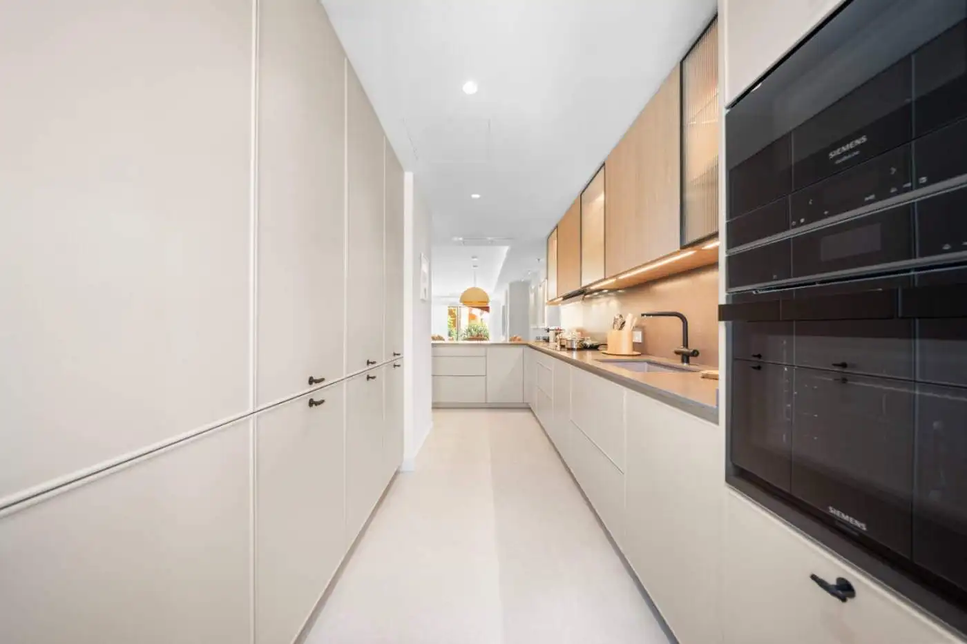 Modern kitchen with sleek cabinetry and built-in appliances in a luxury townhouse.