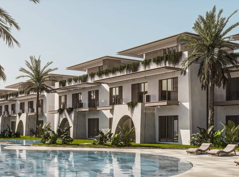 Modern beachfront apartment complex with pool and palm trees.