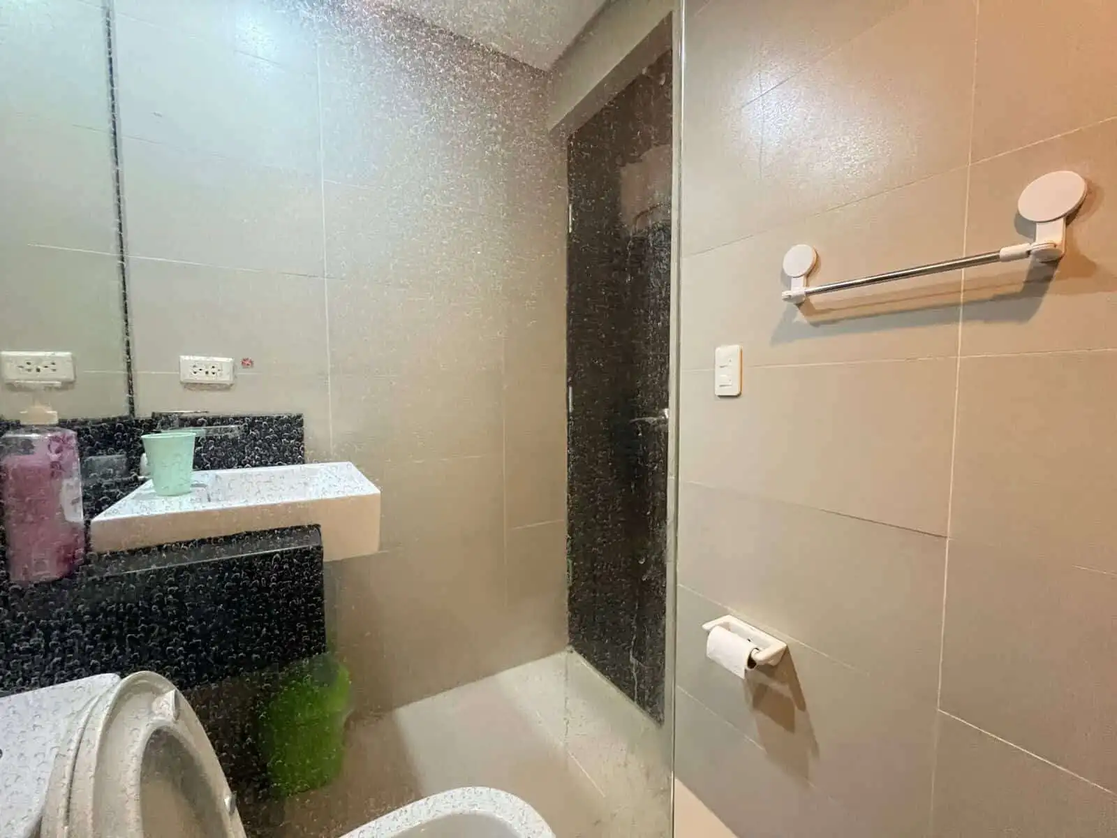 Bathroom with shower, sink, and toilet in Oceanway Residencies Boracay apartment.