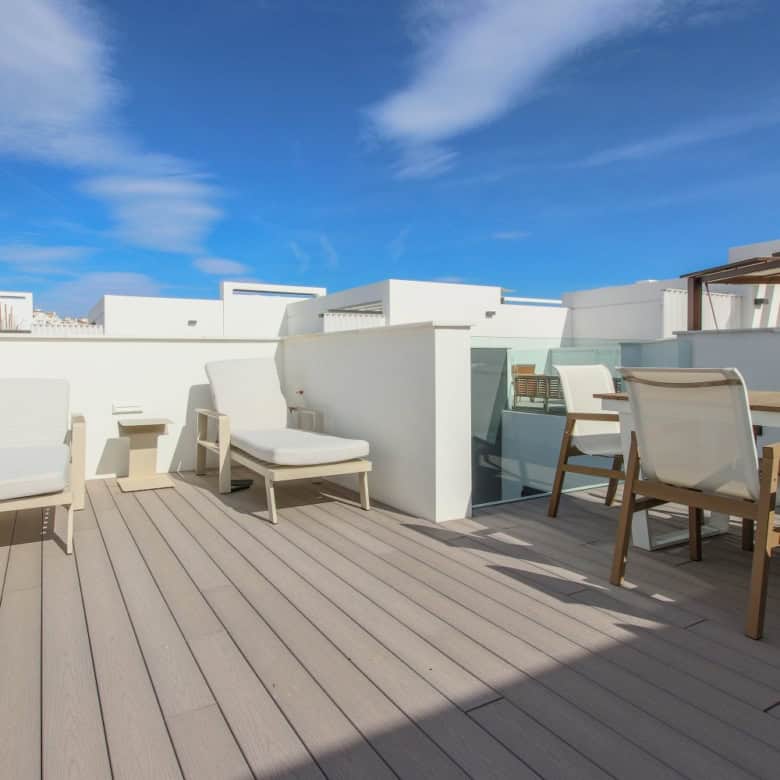 Beachfront terrace with lounge chairs and dining area in Estepona West.
