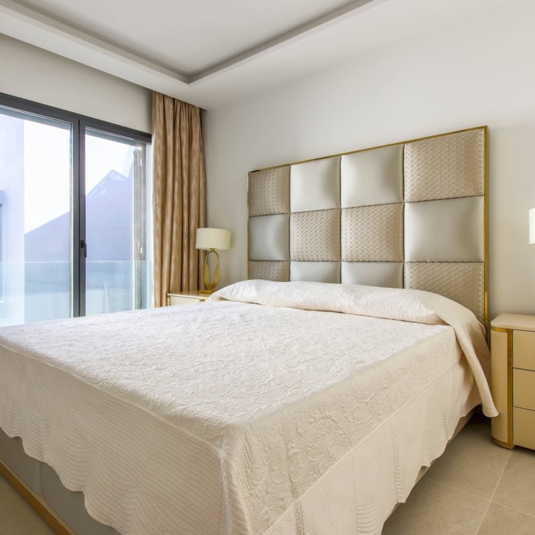 Beachfront bedroom with large window and elegant decor in Estepona West.
