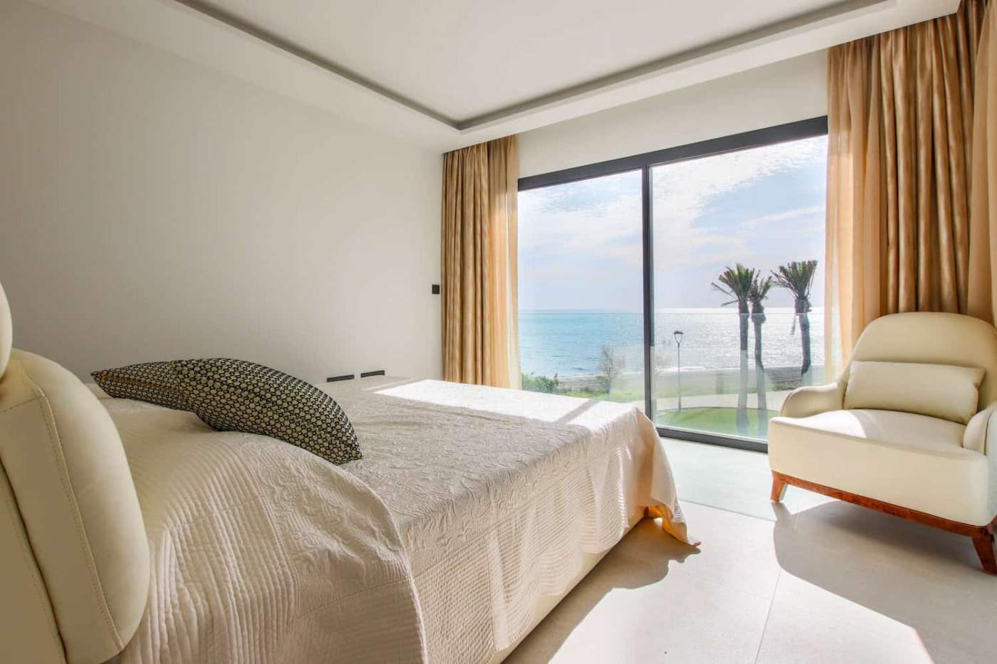 Modern beachfront townhouse bedroom overlooking the sea and palm trees in Estepona West.