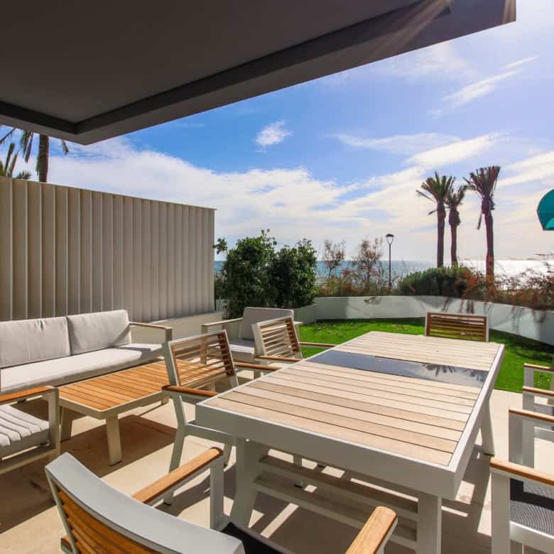 Beachfront terrace with outdoor dining area and lounge chairs in Estepona West.