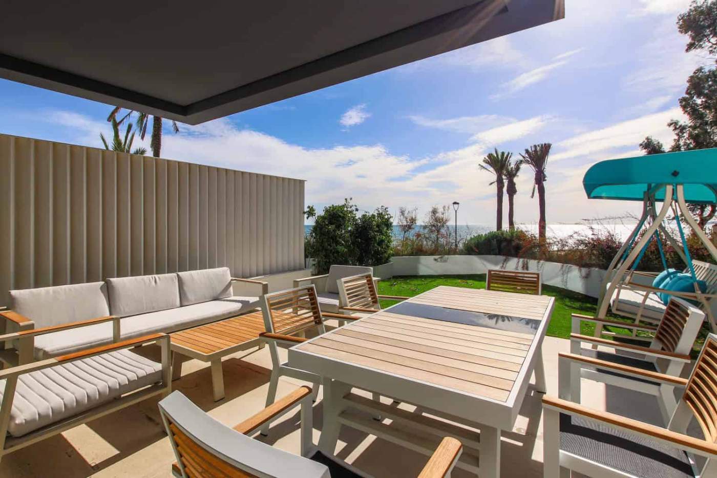 Beachfront terrace with outdoor dining area and lounge chairs in Estepona West.