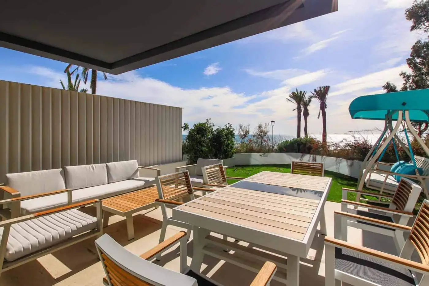 Beachfront terrace with outdoor dining area and lounge chairs in Estepona West.