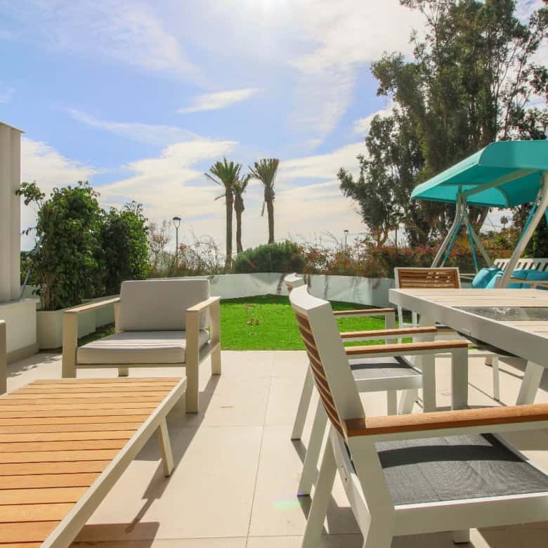 Beachfront terrace with outdoor seating and lush greenery in Estepona West.