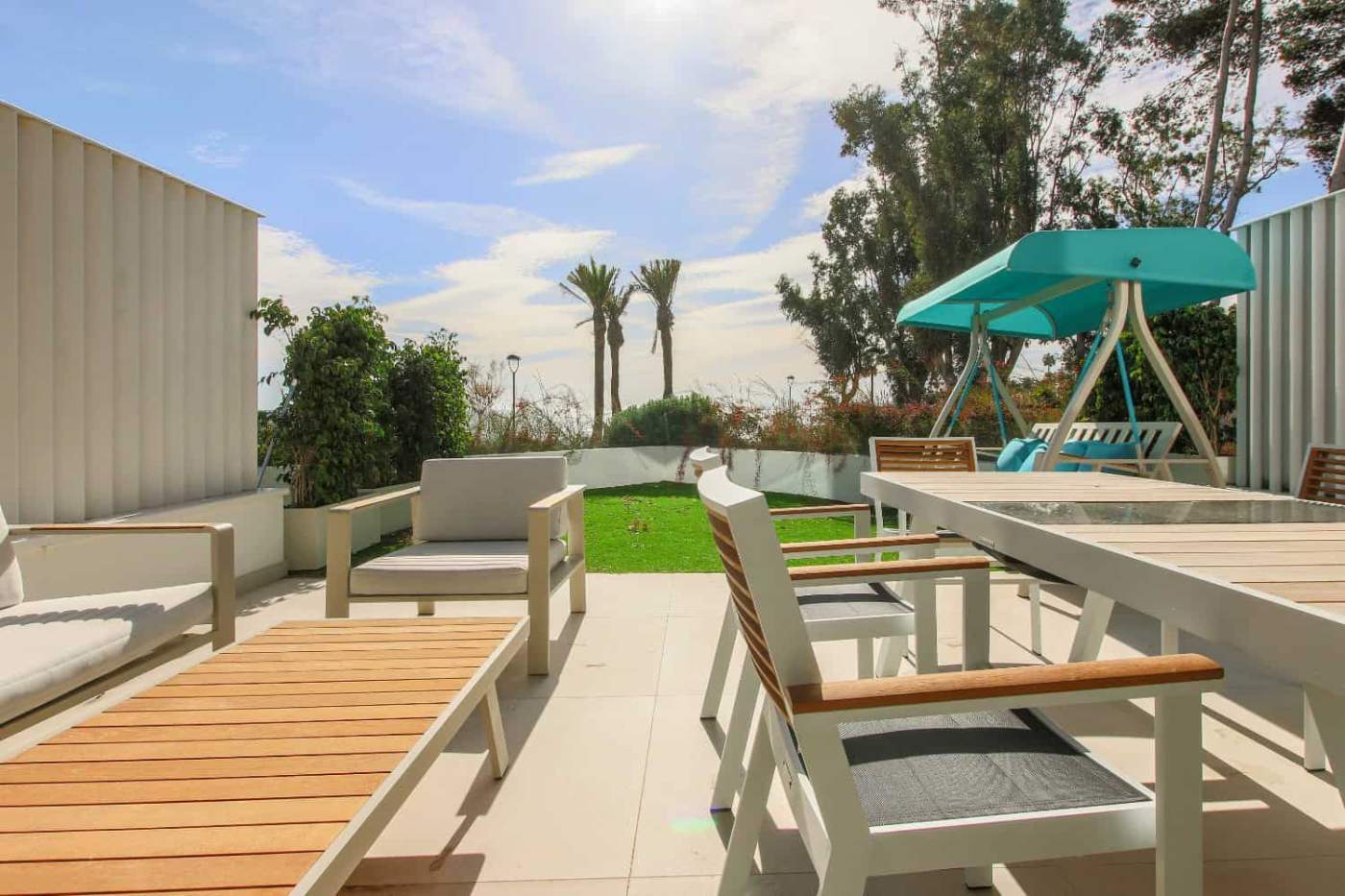 Beachfront terrace with outdoor seating and lush greenery in Estepona West.