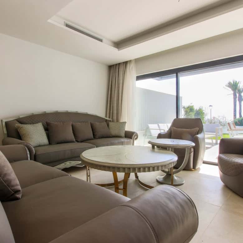 Beachfront townhouse living room with stylish furniture and large glass doors overlooking the sea in.