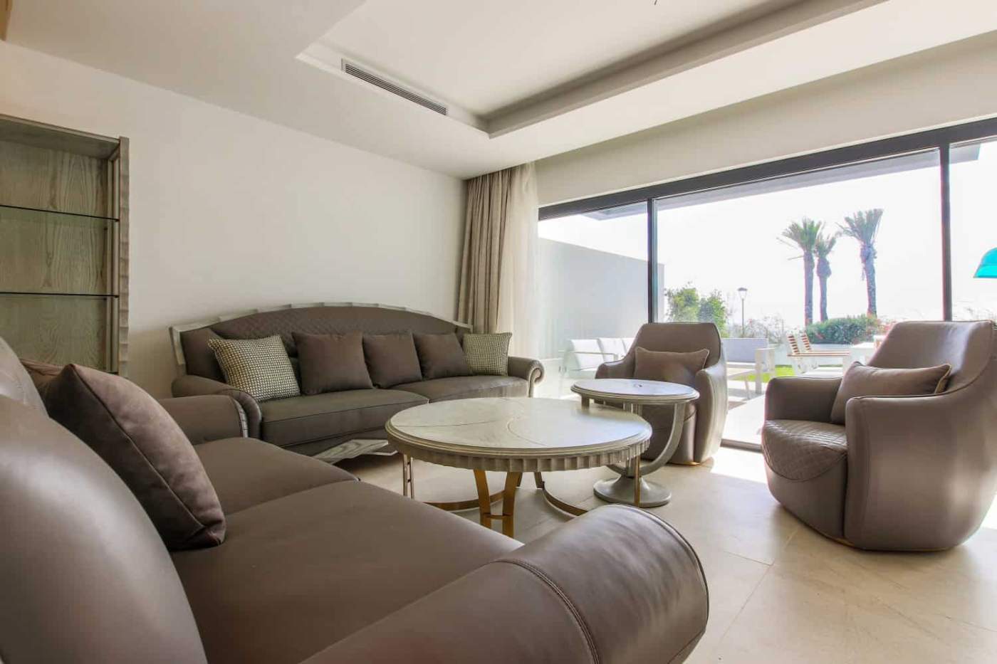 Beachfront townhouse living room with stylish furniture and large glass doors overlooking the sea in.
