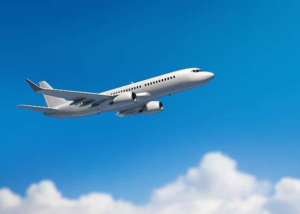 Private jet soaring through blue sky with clouds.