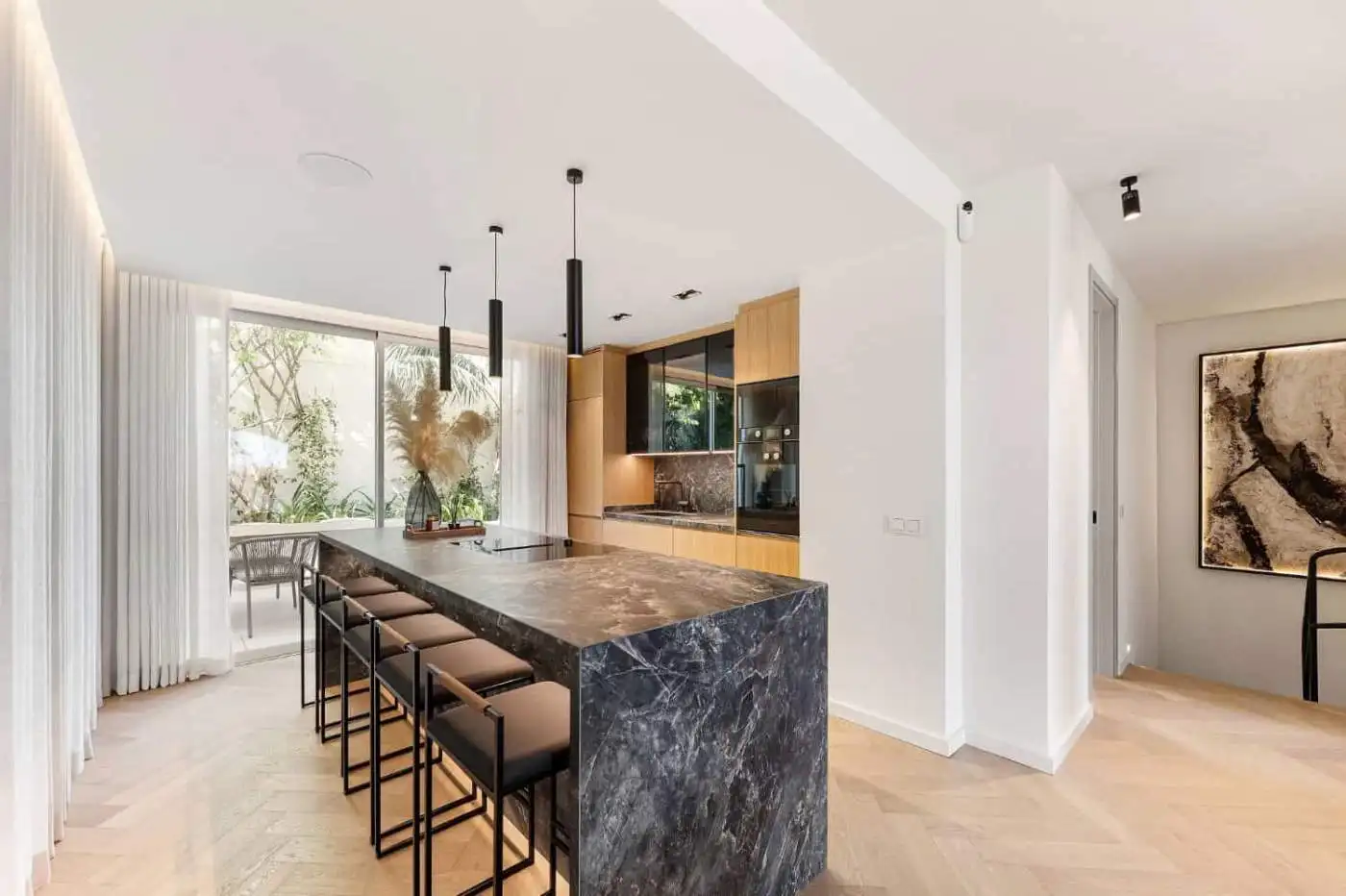 Modern kitchen with marble island in Marbella townhouse.