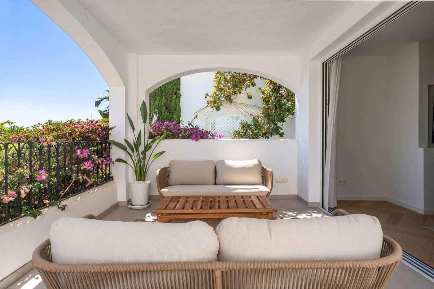 Luxury Townhouse Balcony View Balcony of a luxury townhouse in Club Sierra, Marbella, showcasing outdoor seating and vibrant garde.