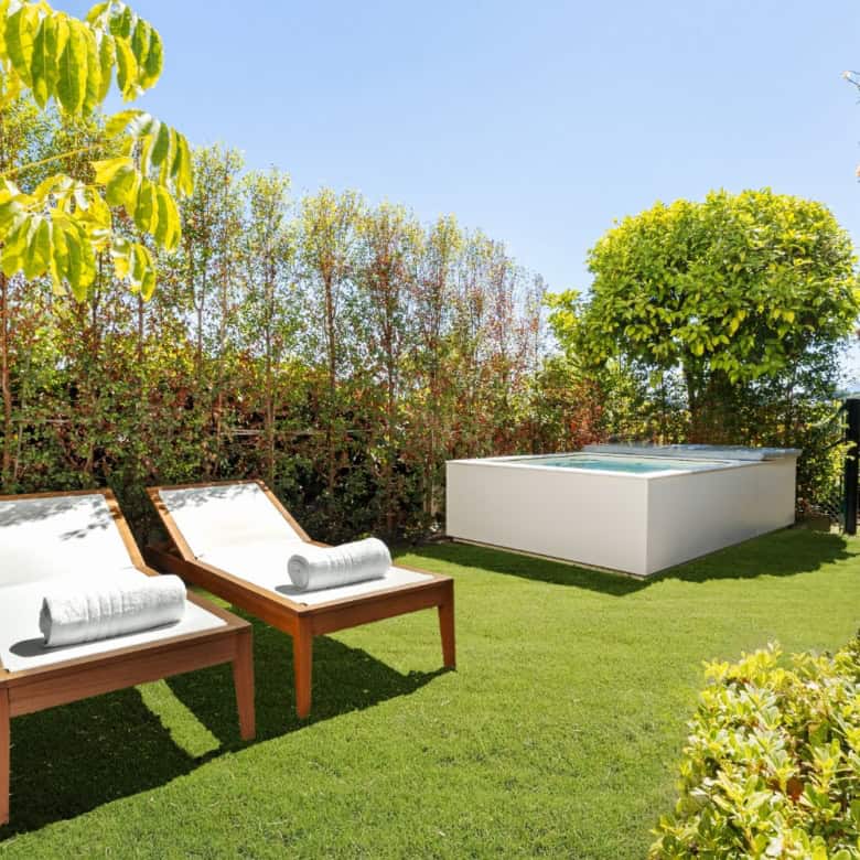 Luxury Townhouse outdoor garden with sun loungers and hot tub in Marbella.