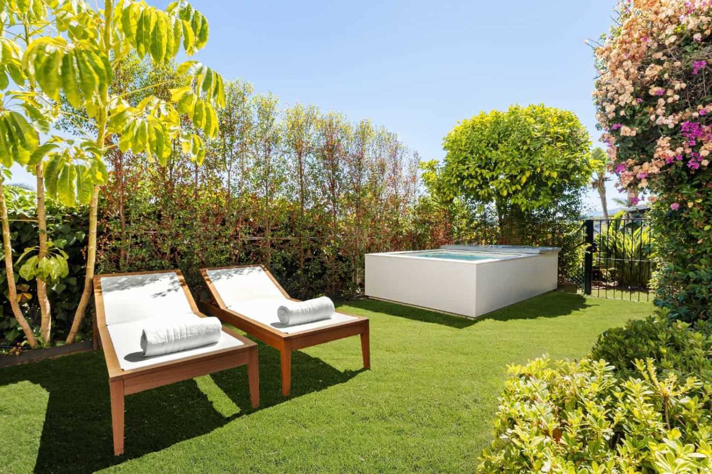 Luxury Townhouse in Club Sierra, Golden Mile Marbella Luxury Townhouse outdoor garden with sun loungers and hot tub in Marbella.