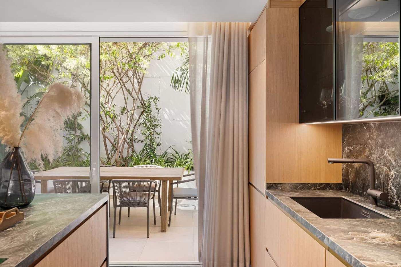Luxury Townhouse Marbella Interior Modern kitchen with sliding glass doors to outdoor patio.