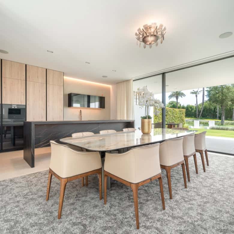 Elegant contemporary dining room with large windows and scenic views.