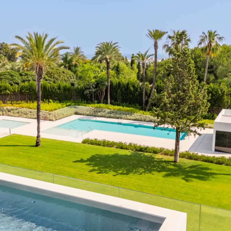 Elegant villa featuring a rooftop pool and lush garden views in Nueva Andalucía.