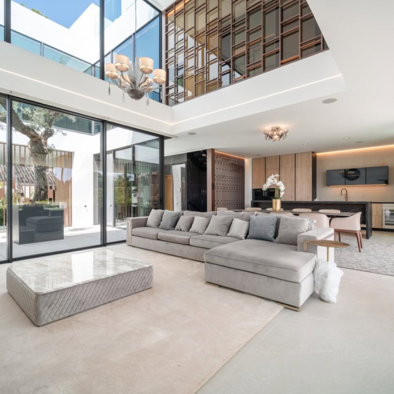 Spacious modern living room with floor-to-ceiling windows and stylish decor.