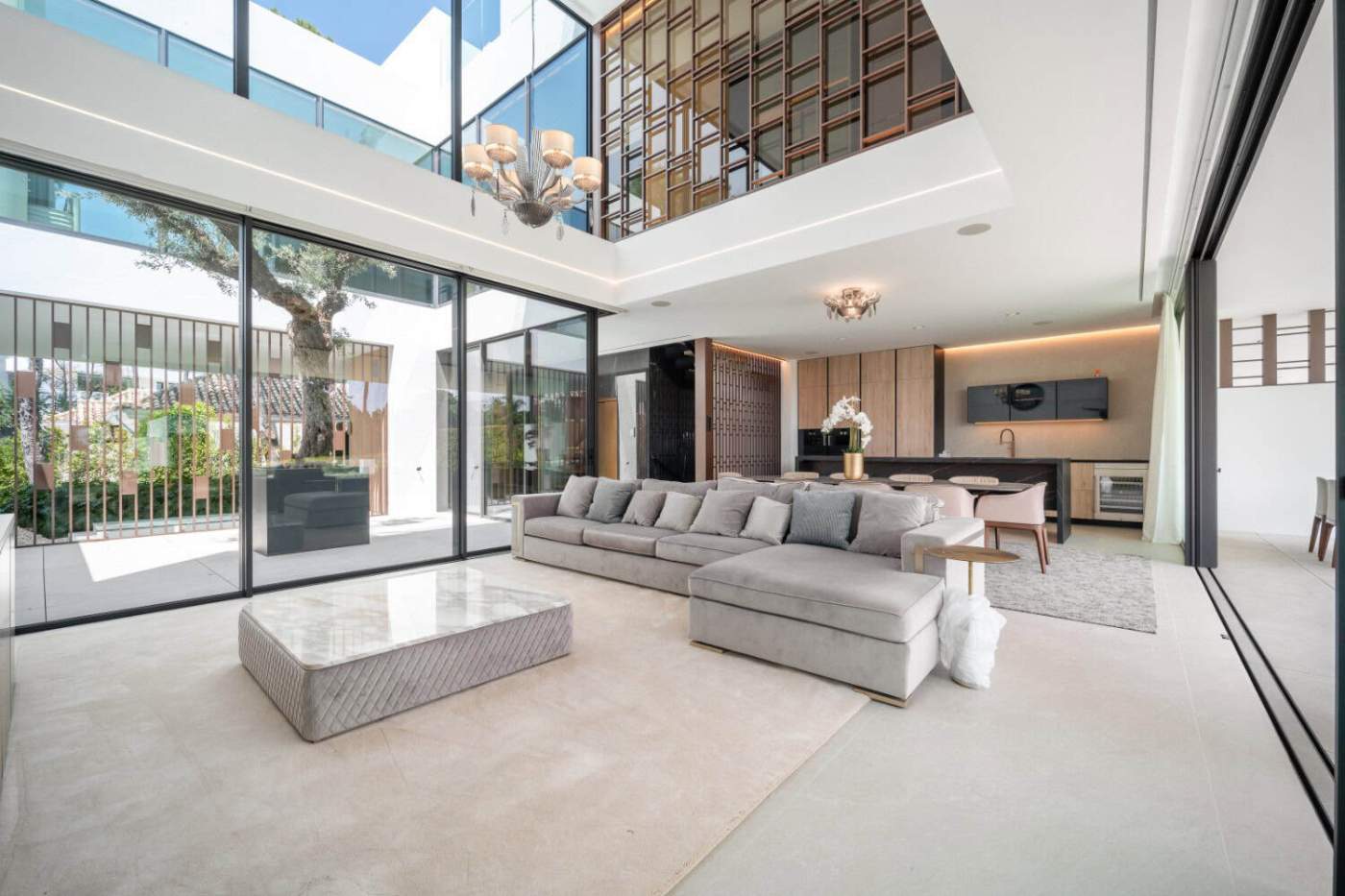 Contemporary Villa with Rooftop Pool in Nueva Andalucía Spacious modern living room with floor-to-ceiling windows and stylish decor.
