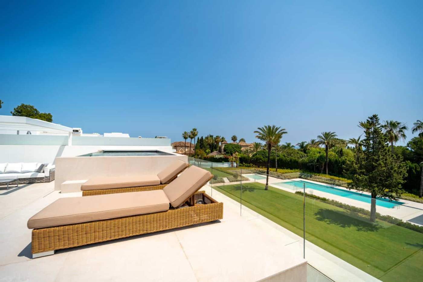 Luxury Villa Rooftop Lounge with Pool and Views Luxury villa rooftop lounge with sunbeds, pool, and scenic views of the surrounding landscape.