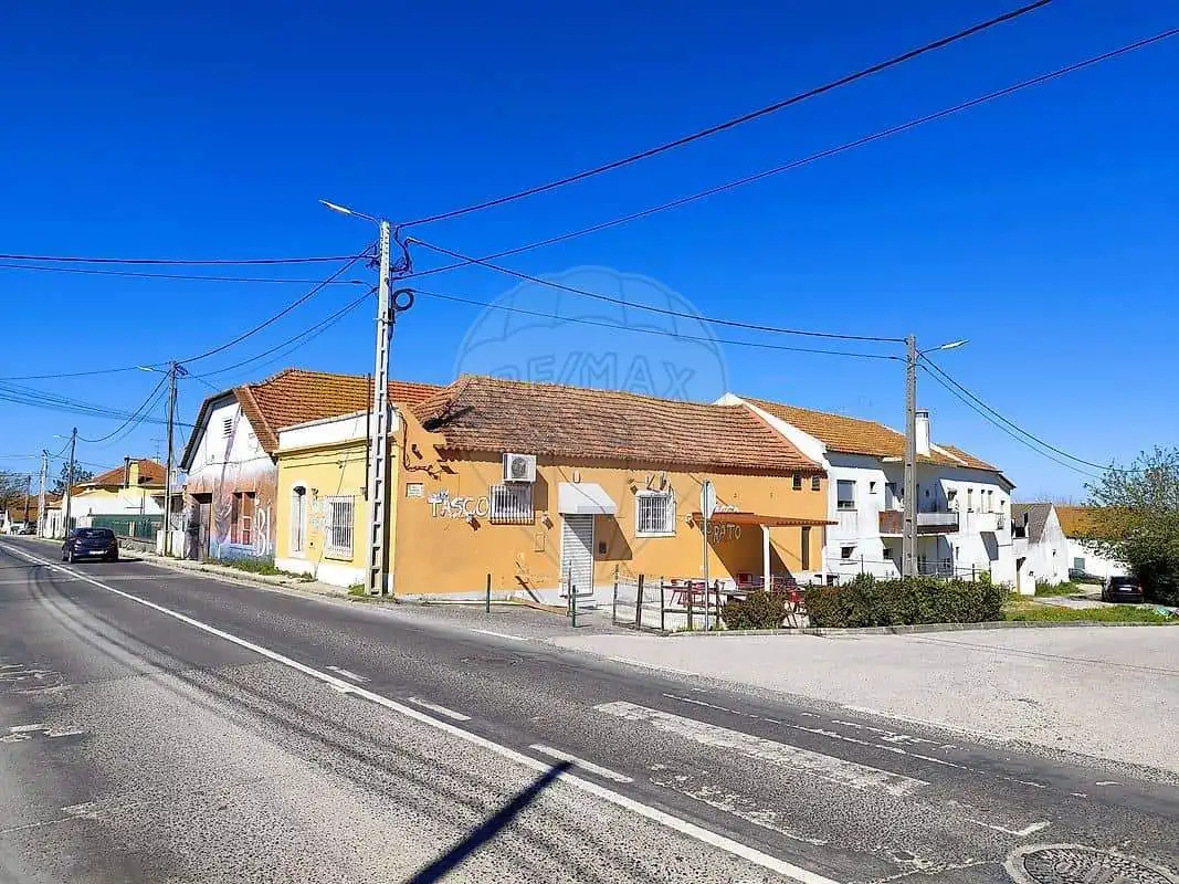 Land plot for sale in Cabanas Setubal Portugal with nearby houses and clear blue sky.