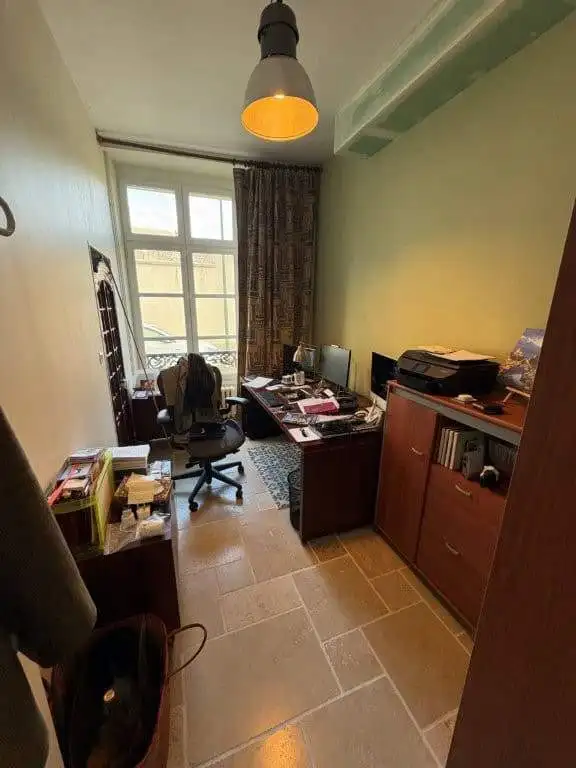 Home office setup with desk, chair, and computer in a charming French house.