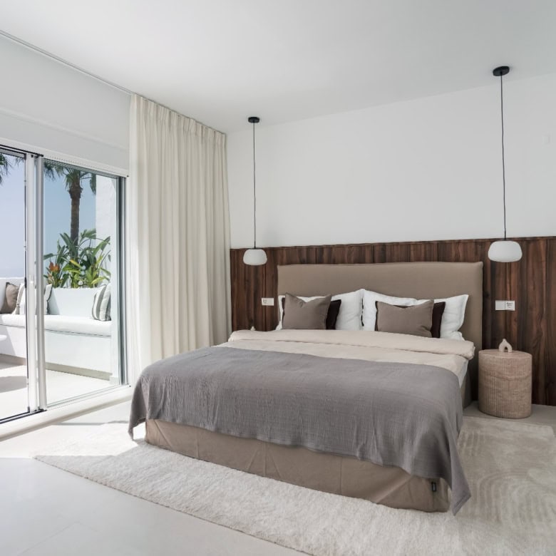 Luxury duplex penthouse bedroom with modern decor and ocean views in La Quinta Village.
