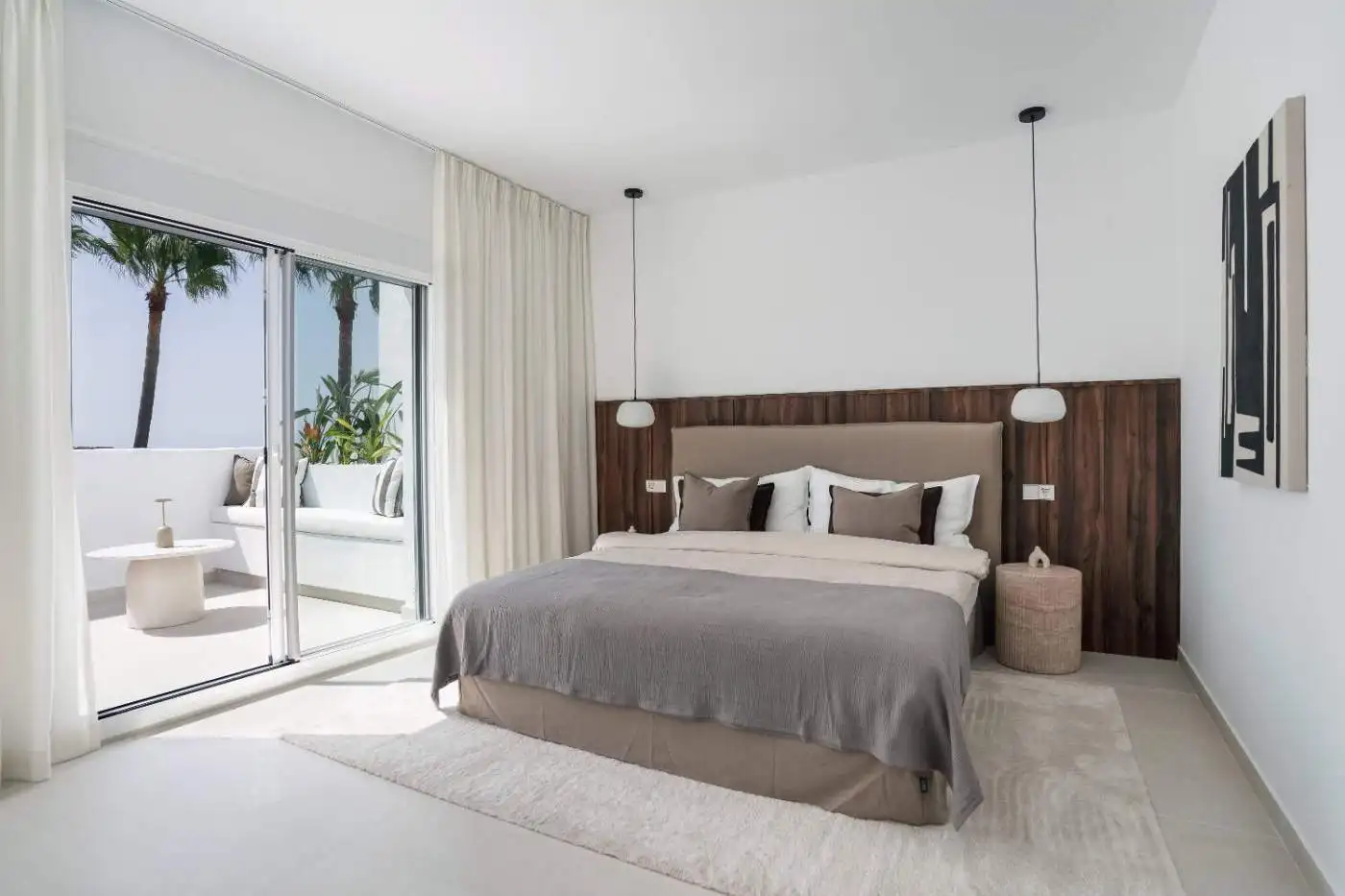 Luxury duplex penthouse bedroom with modern decor and ocean views in La Quinta Village.