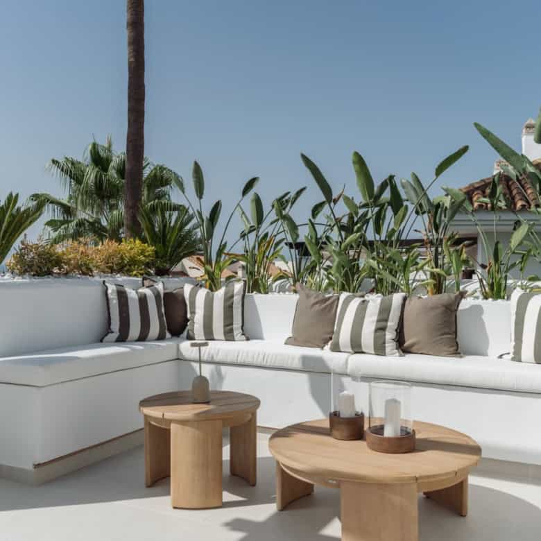 La Quinta Village corner duplex penthouse with outdoor seating and lush greenery.