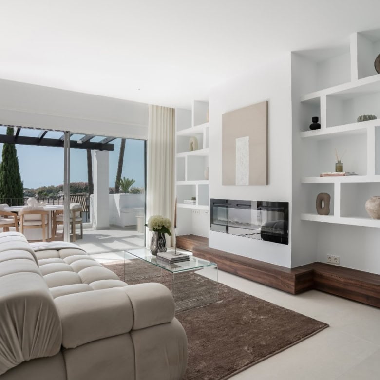 Elegant living room with modern decor and large windows overlooking outdoor terrace.