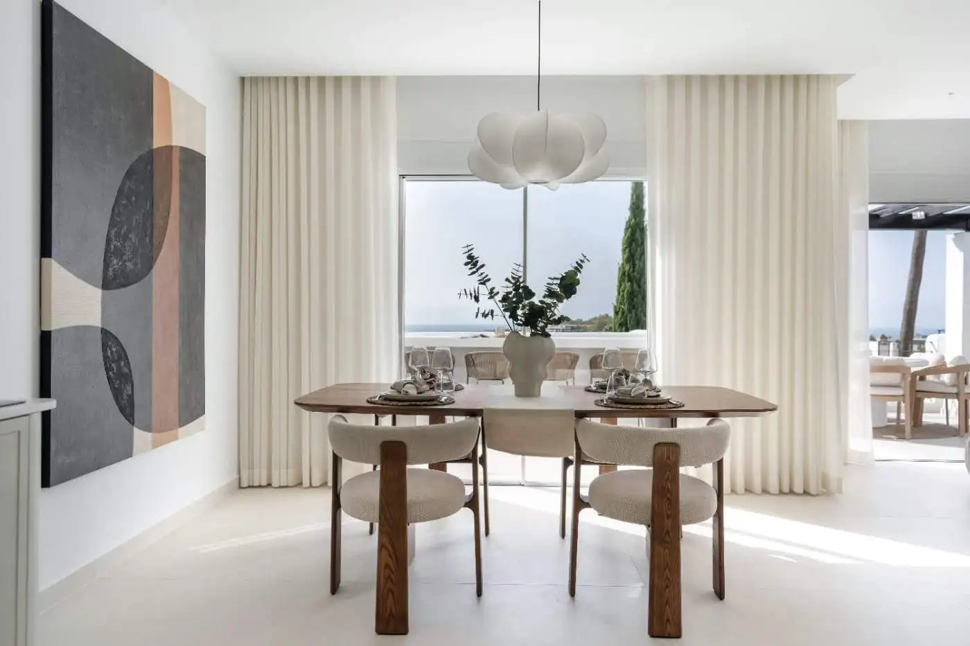 Elegant dining area with large window overlooking the sea in La Quinta Village Corner Duplex Penthou.