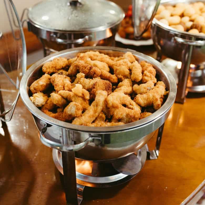 Delicious crispy fried chicken bites served in a buffet setting. Perfect for gatherings and parties.
