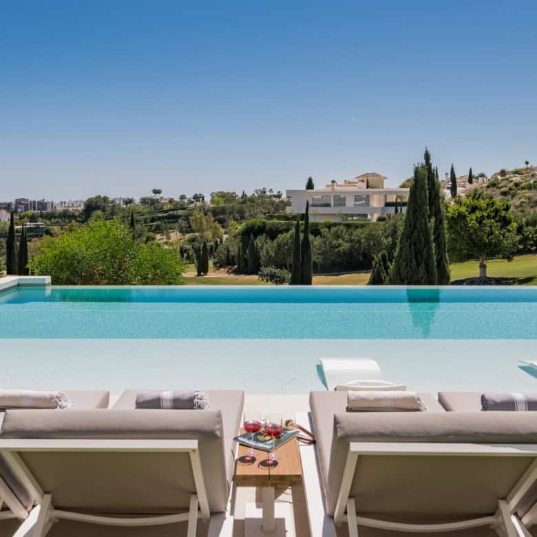 Elegant modern villa with a stunning infinity pool overlooking lush greenery in Los Flamingos.