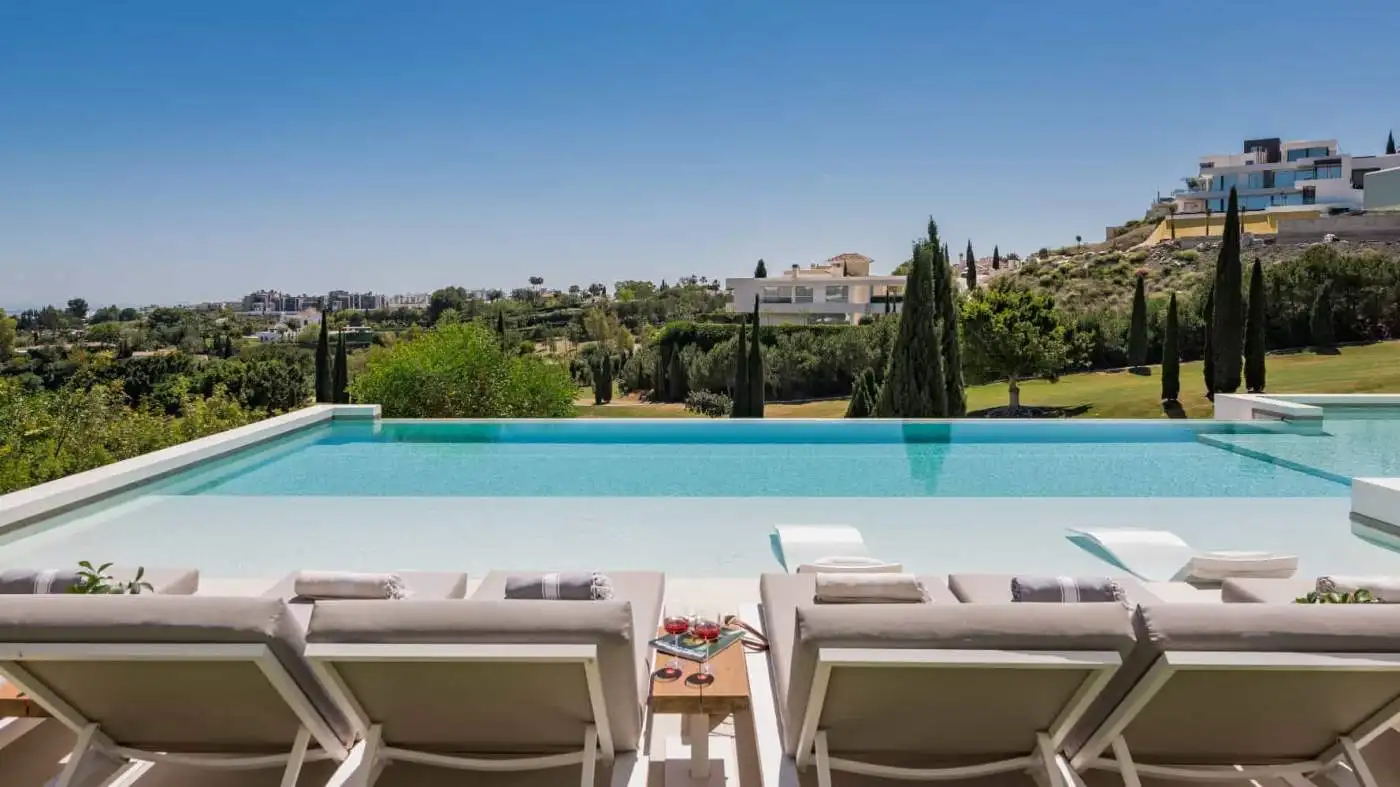 Elegant modern villa with a stunning infinity pool overlooking lush greenery in Los Flamingos.
