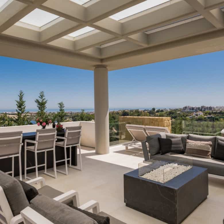 Modern villa terrace overlooking Los Flamingos with seating and panoramic city views.