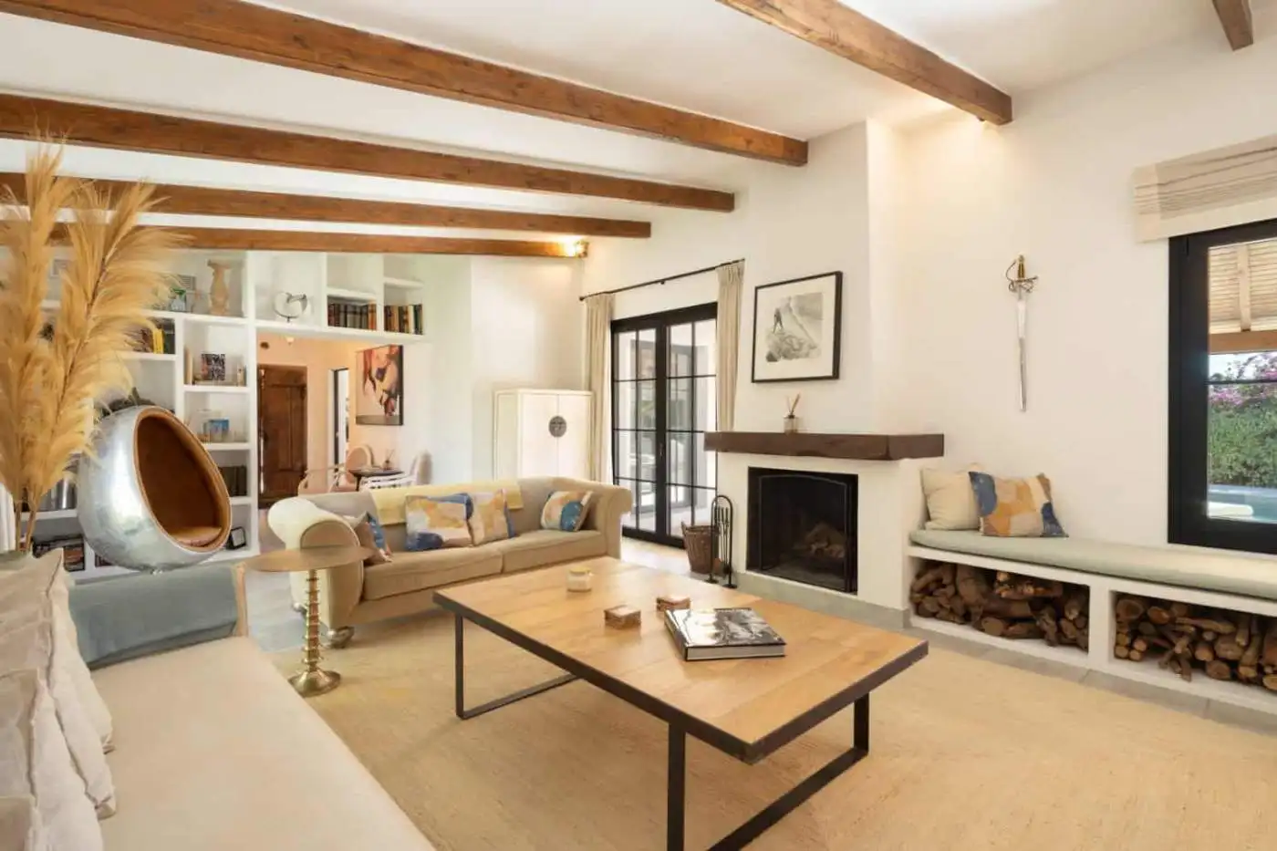 Bright and spacious living area in Casa Teresita with rustic wooden beams and cozy fireplace.