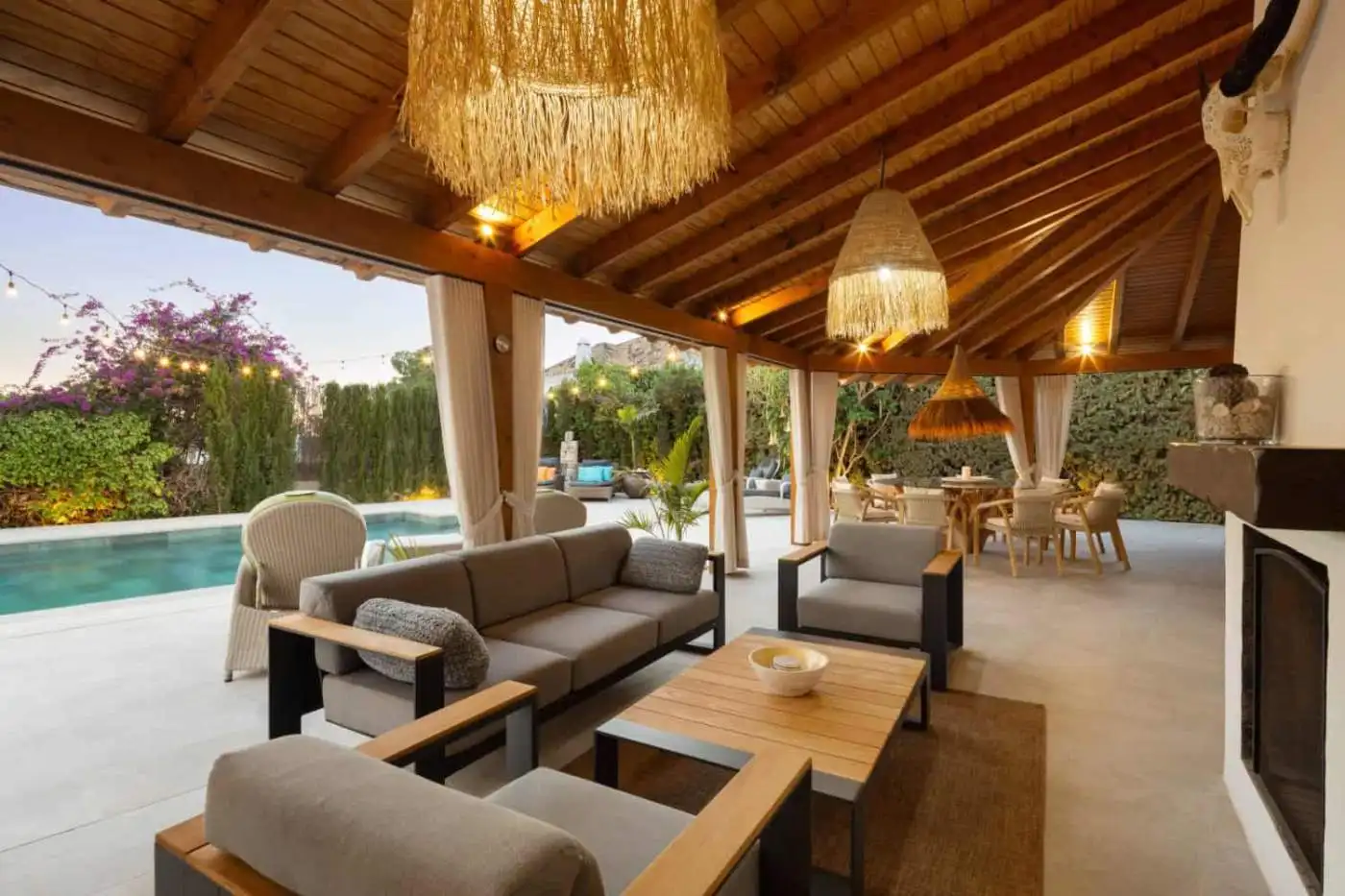 Spacious covered patio with seating, pool, and garden at Casa Teresita property.