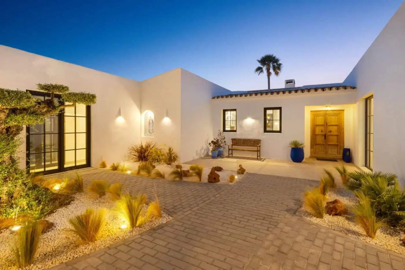 Beautiful exterior view of Casa Teresita with modern architecture and landscaped courtyard at dusk.