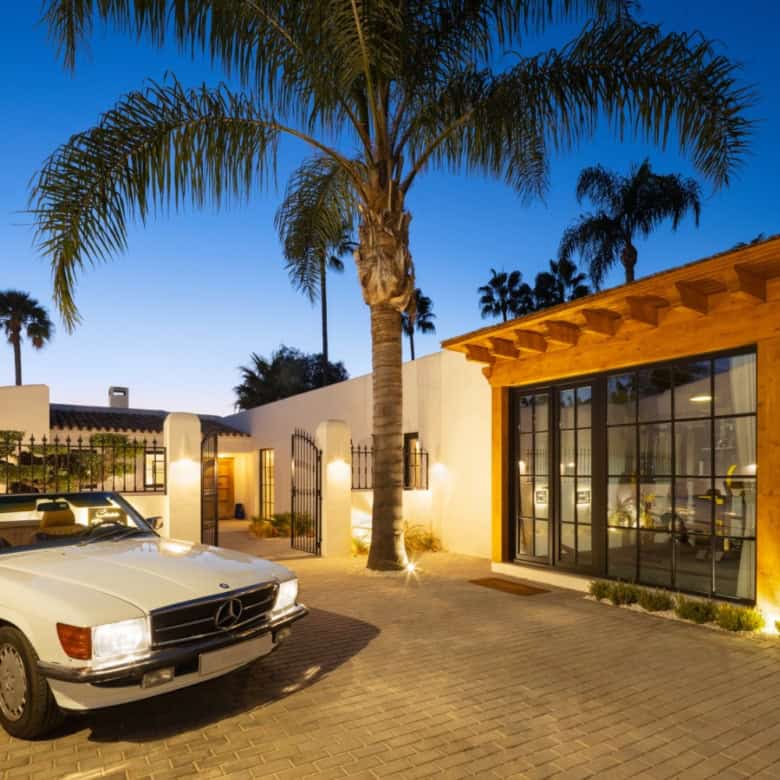 Excl Listing Casa Teresita: Elegant property with palm trees and modern design at sunset.