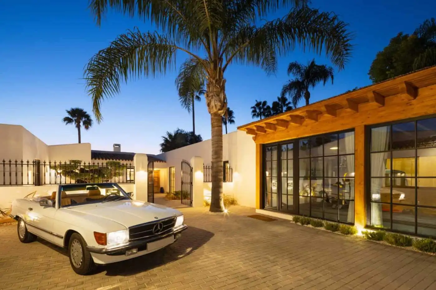 Excl Listing Casa Teresita: Elegant property with palm trees and modern design at sunset.