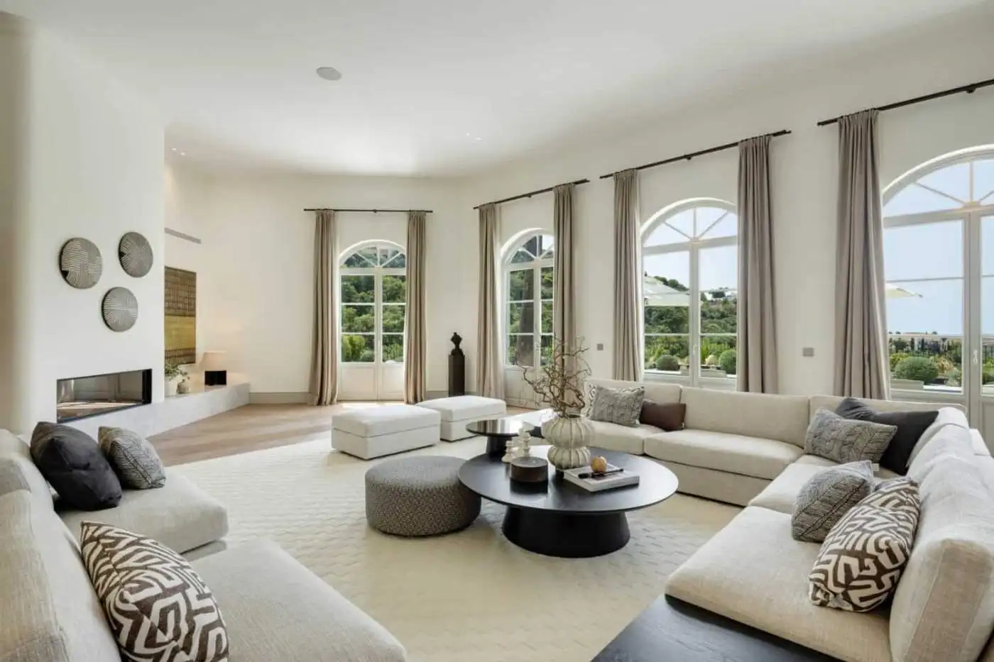 Spacious living area with large arched windows offering scenic views in Villa Liora, La Zagaleta.