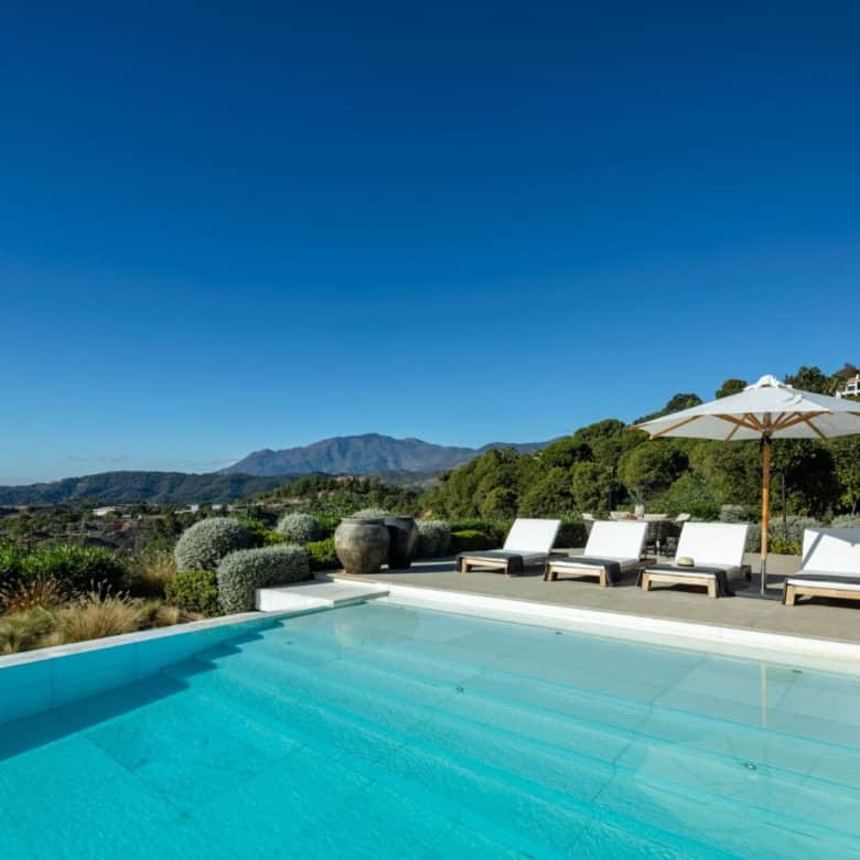 Luxury mansion with infinity pool overlooking Marbella and surrounding mountains.